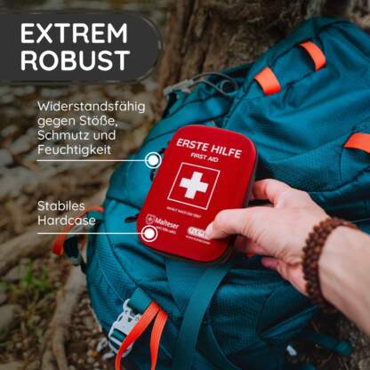 erste hilfe set am rucksack mit einer hand