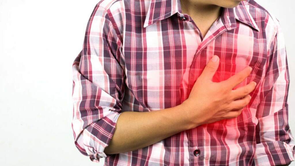 Man hat schmerzen an der Brust und hält seine Hand an der Herz Gegend