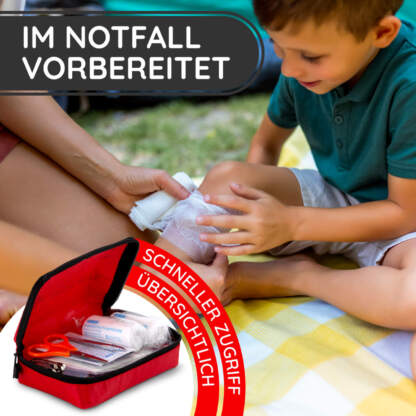ein verband wird bei einem verletzen kind angebracht, im vordergrund unser mini erste hilfe set