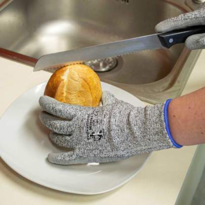 Schnittschutzhandschuhe im Einsatz in der Küche beim schneiden eines Brötchens