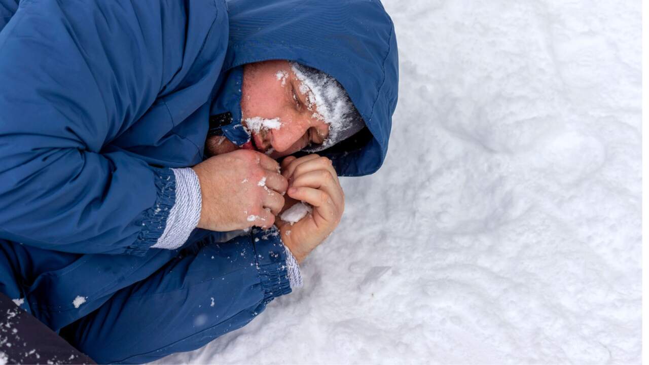 Ein mann ist unterkühlt und liegt im schnee